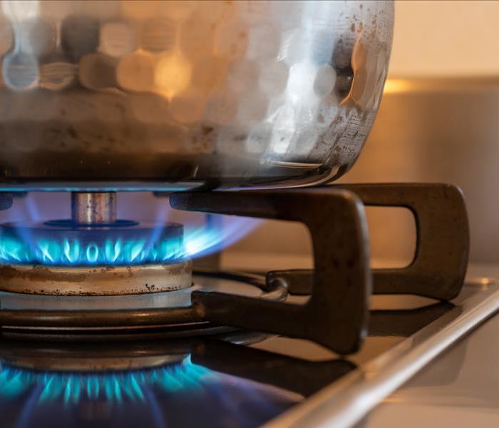 A gas stove emitting fire from the front burner